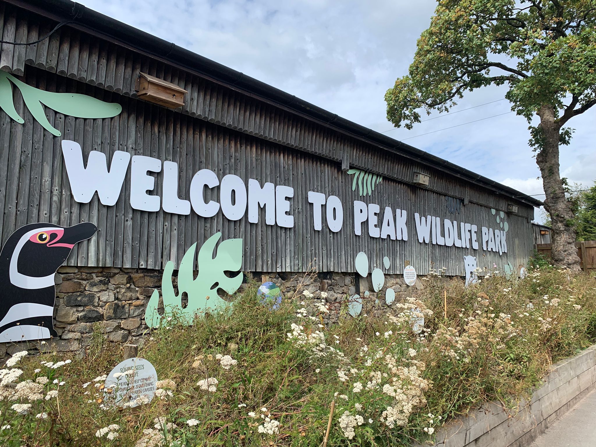 The "Welcome to Peak Wildlife Park" sign painted on the barn at the entrance