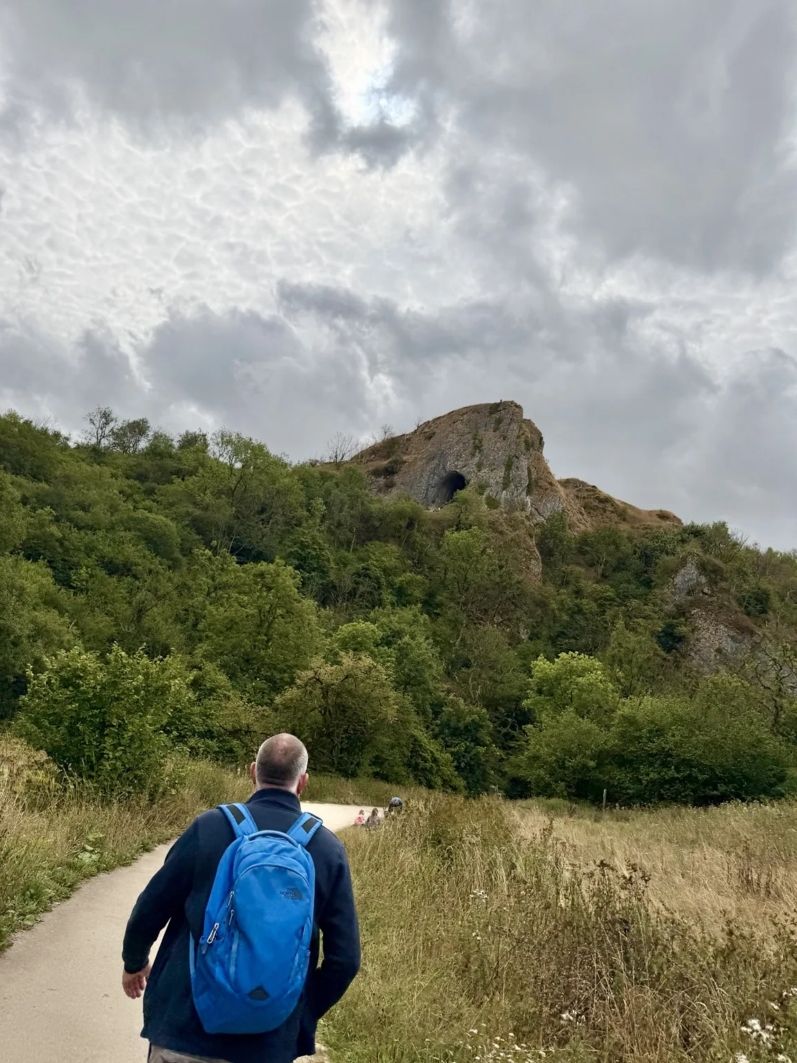 A walker approaching Thor's Cave in the Manifold Valley