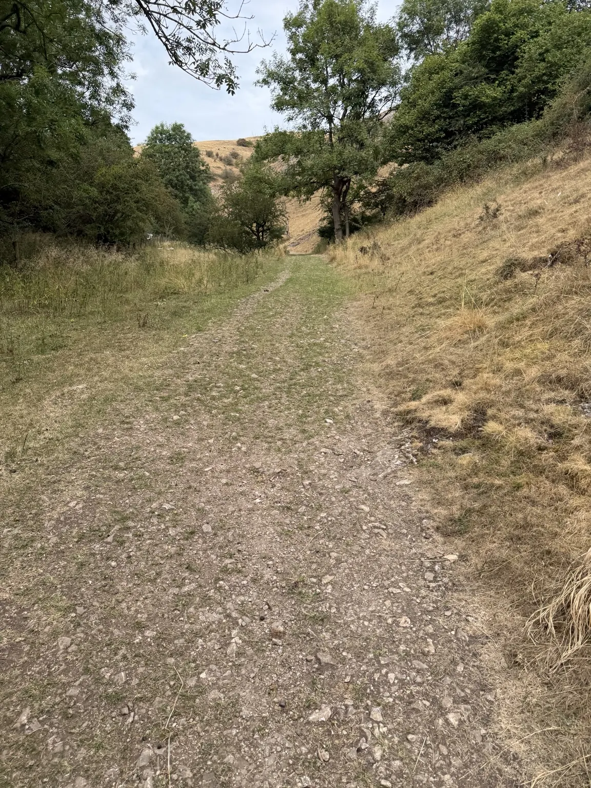An empty stony path running between the hills
