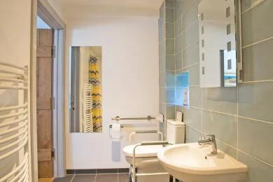 The ground-floor accessible bathroom at Morridge View, with grab rails and a mobile shower chair